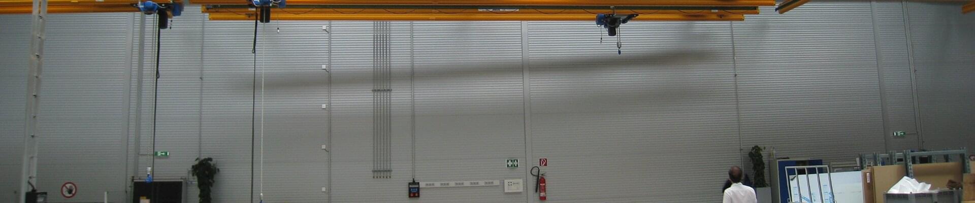 System przenośników podwieszanych firmy ABUS w hali produkcyjnej profili aluminiowych i kompozytów w Austrii 