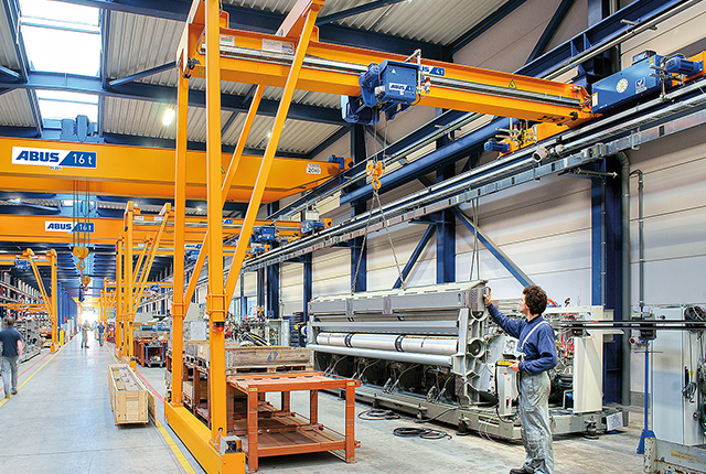 Suwnica półbramowa ABUS w hali przemysłowej o udźwigu do 10 t i rozpiętości do 15 m, zapewniająca elastyczny transport materiałów w miejscach pracy.