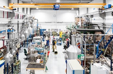 Nowoczesna hala produkcyjna wyposażona w maszyny przemysłowe oraz urządzenie dźwignicowe ABUS, zapewniające precyzyjny transport materiałów.